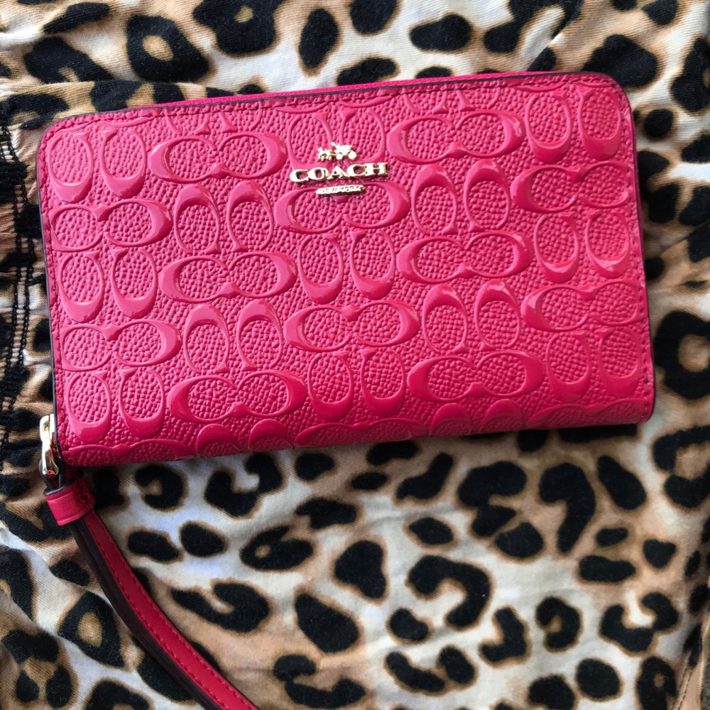 Pink leather coach wallet with tag inside.